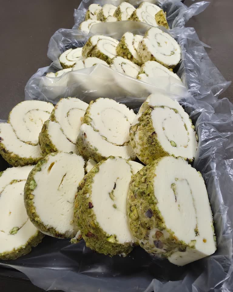 Freshly cut spirals of Ashta booza laid out in a lined production tray.